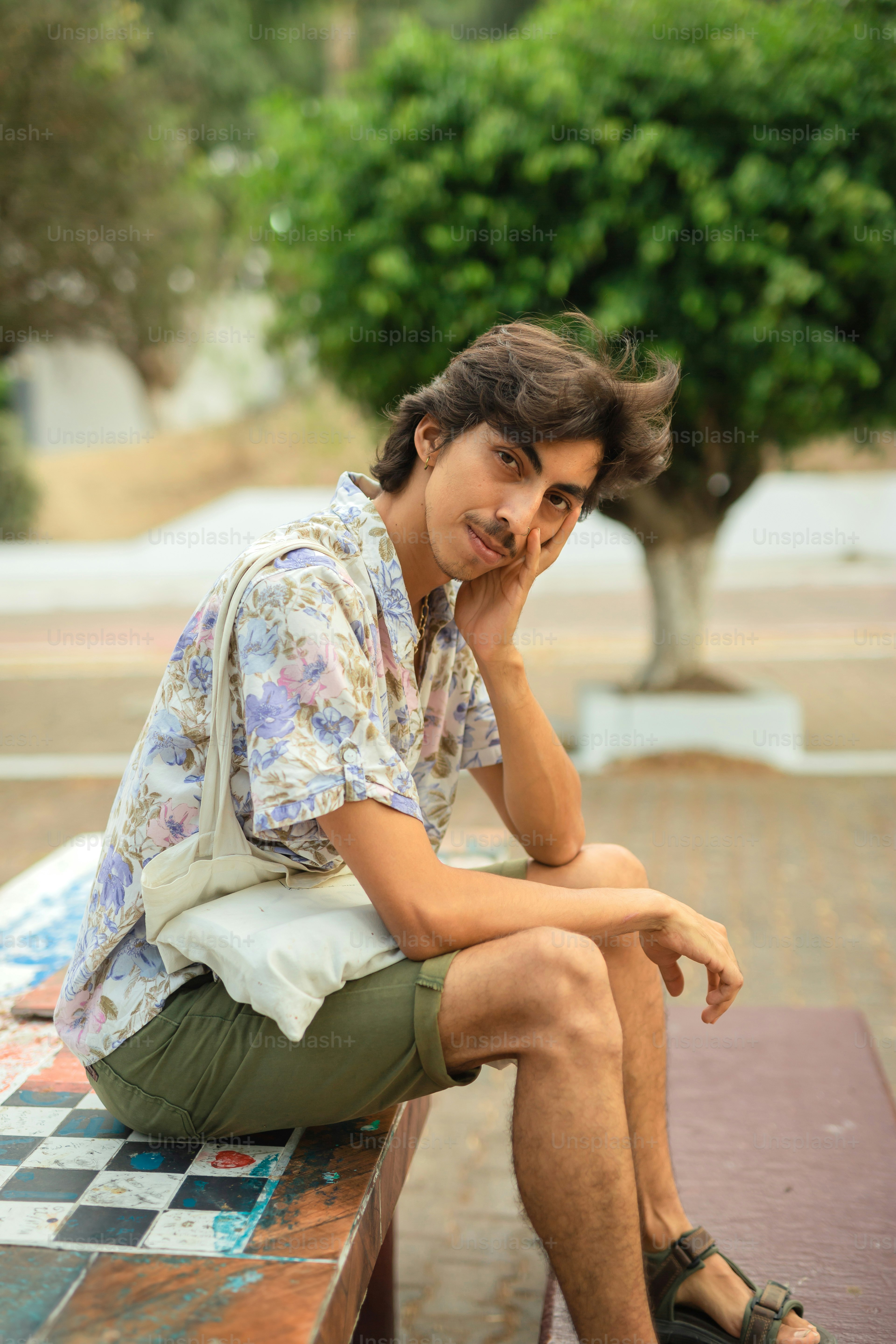 a man sitting on a bench with his hand on his face