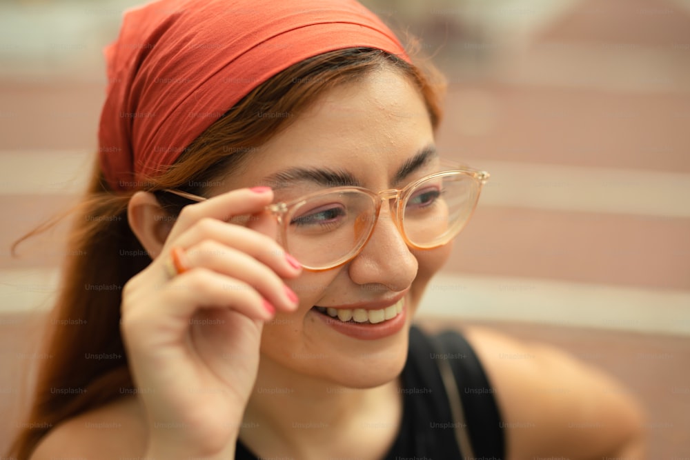 une femme portant des lunettes et un bandeau rouge