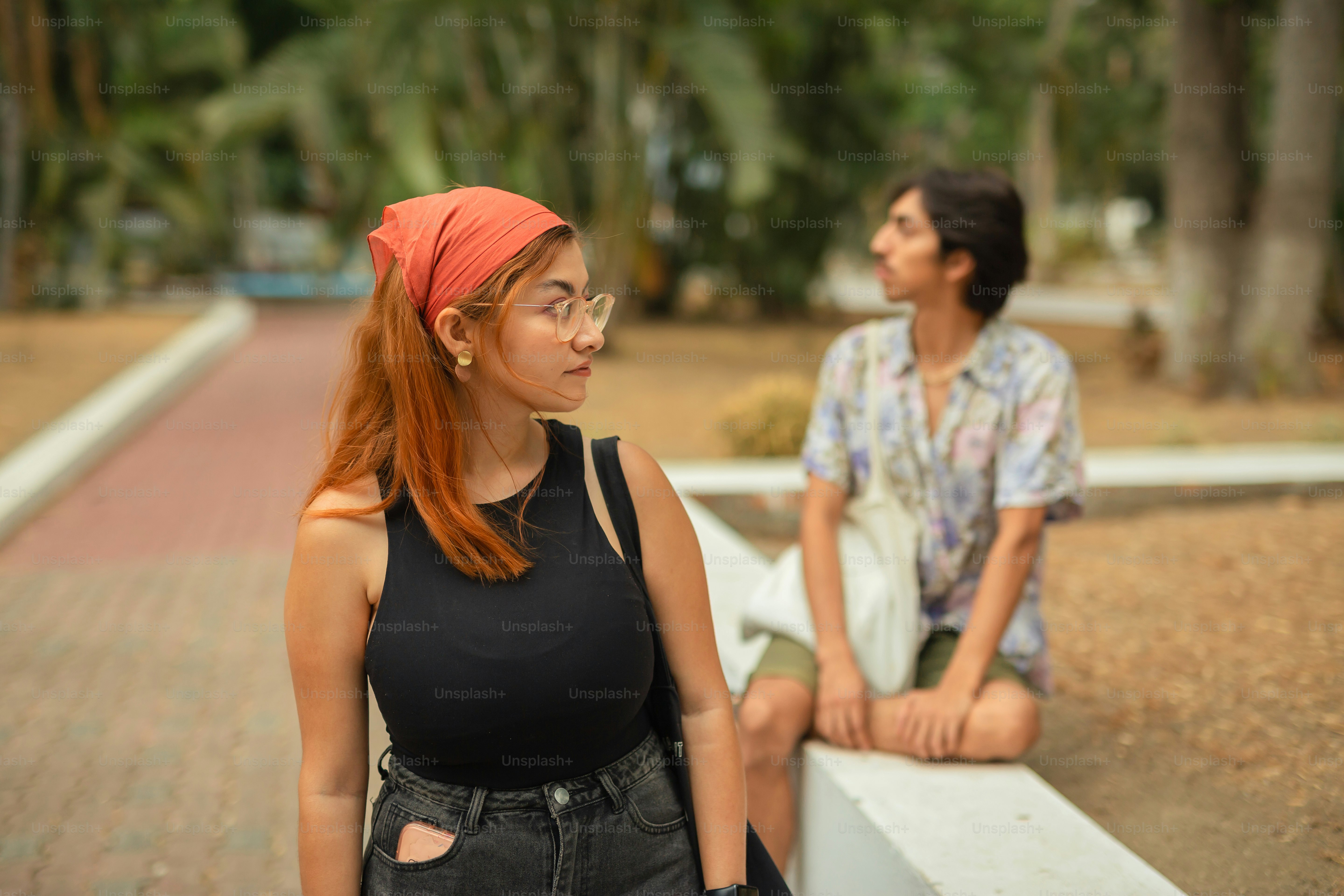 a woman sitting on a bench next to a man