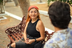 a woman sitting on a bench talking to another woman