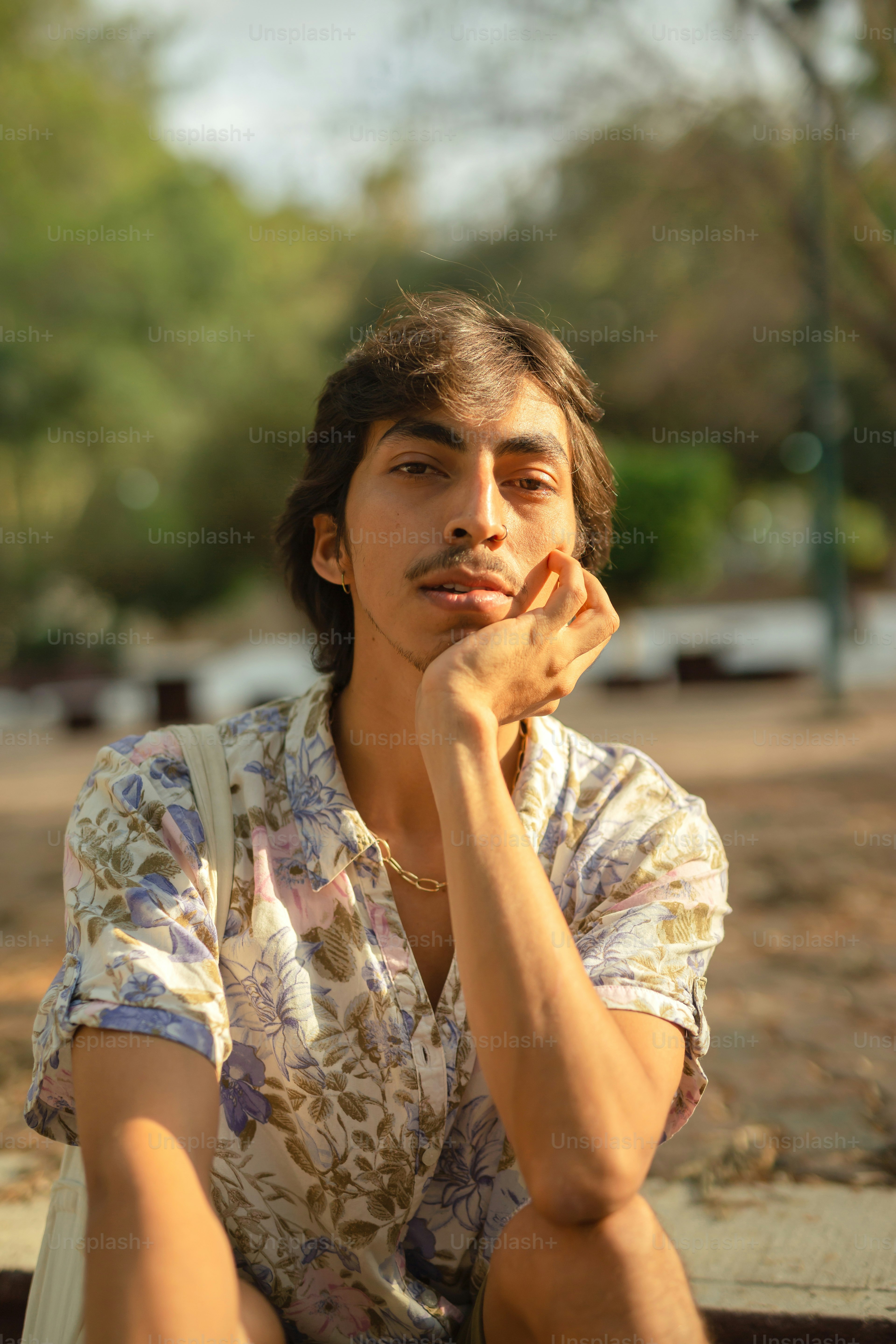 a man sitting on a bench with his hand under his chin