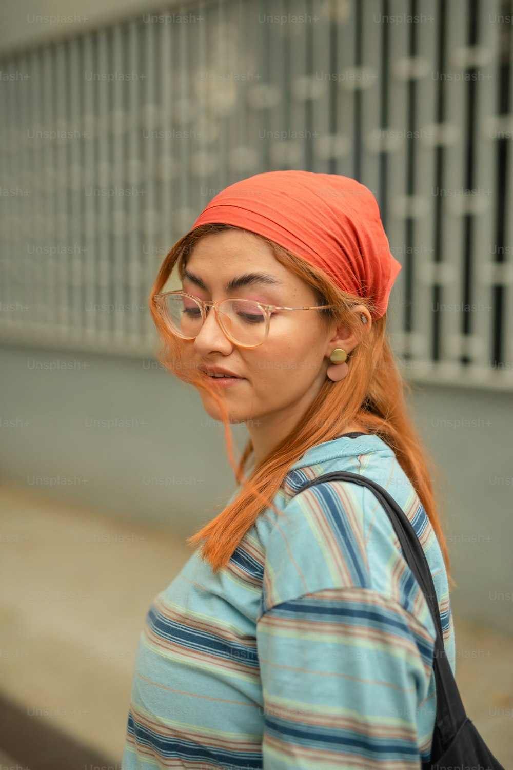 a woman with red hair wearing glasses and a turban