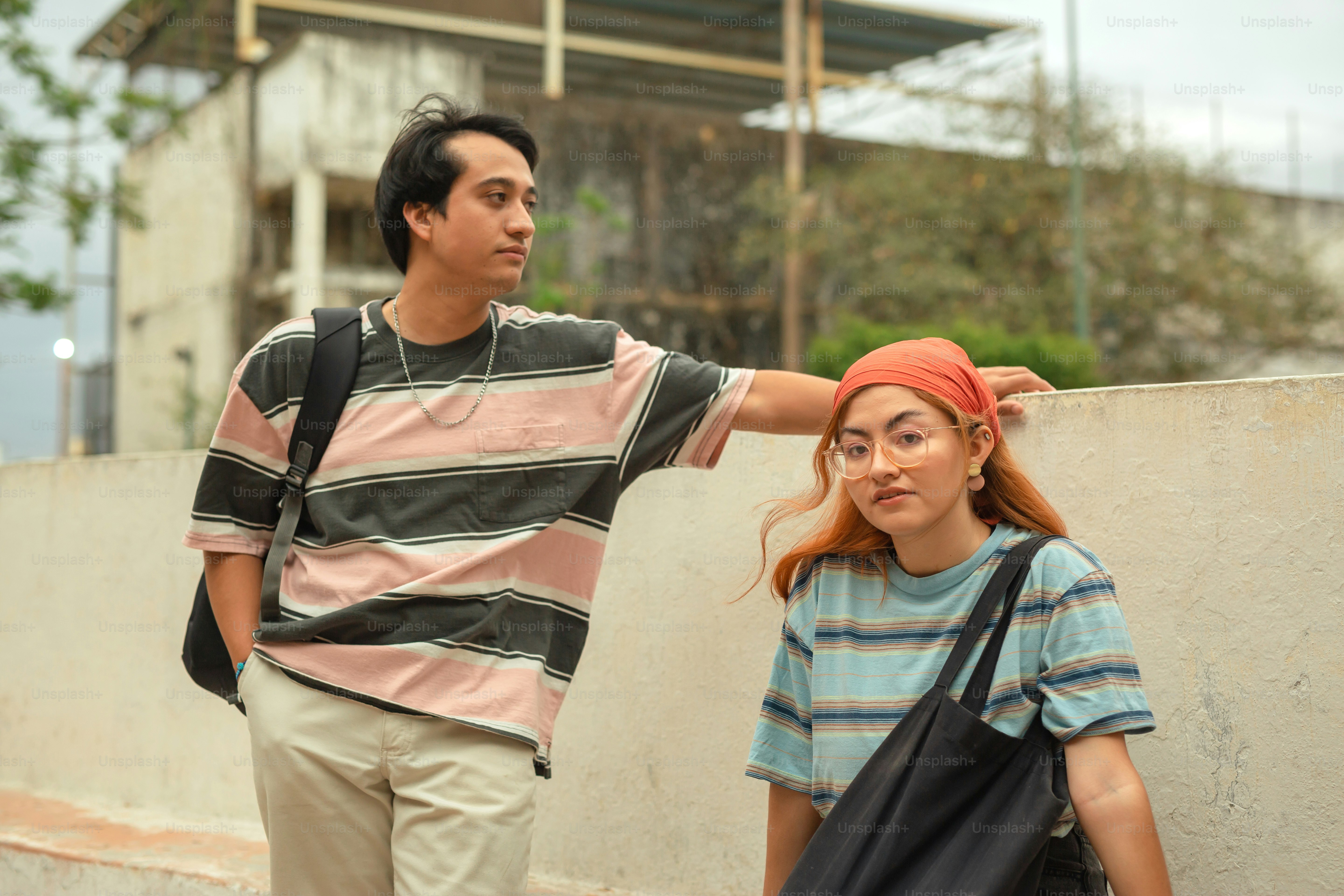 a man standing next to a woman near a wall