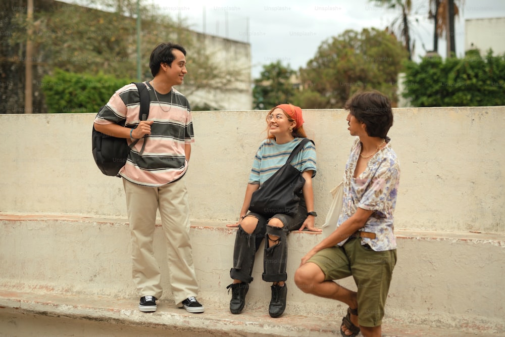 a man standing next to a woman sitting on a wall