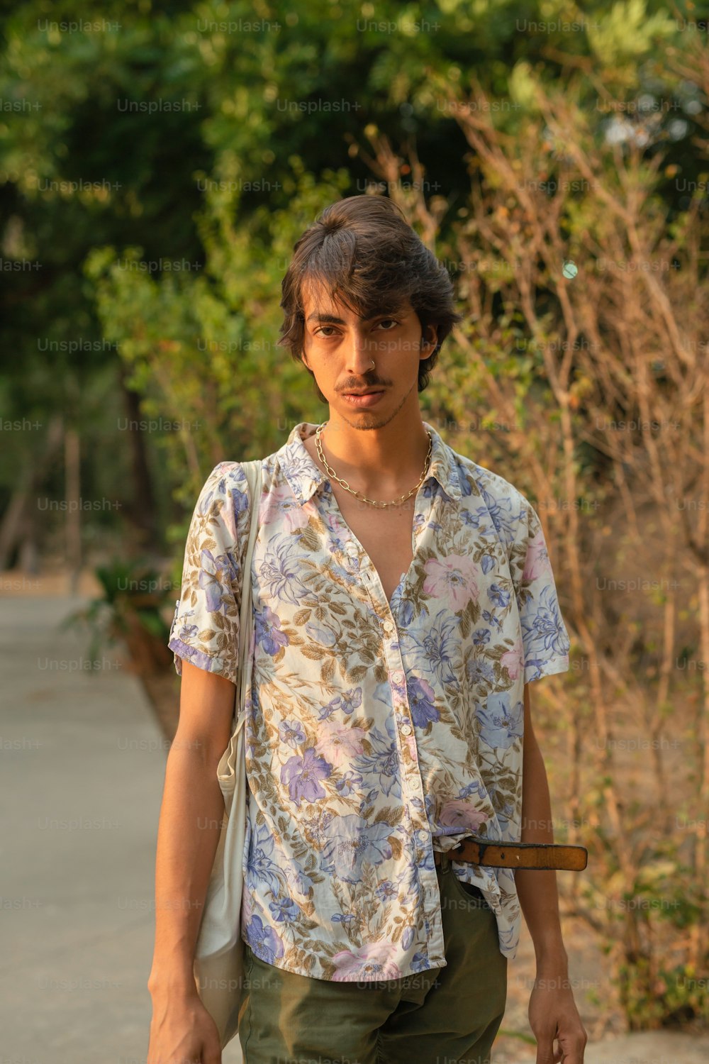 a young man walking down a street holding a skateboard