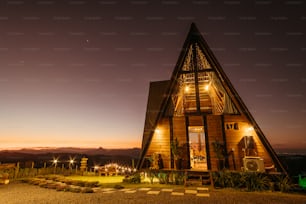 a small wooden house with a lit up porch