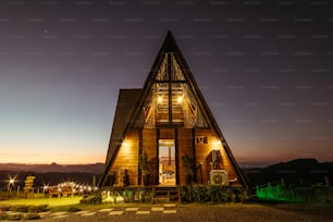 a small wooden house with lights on at night