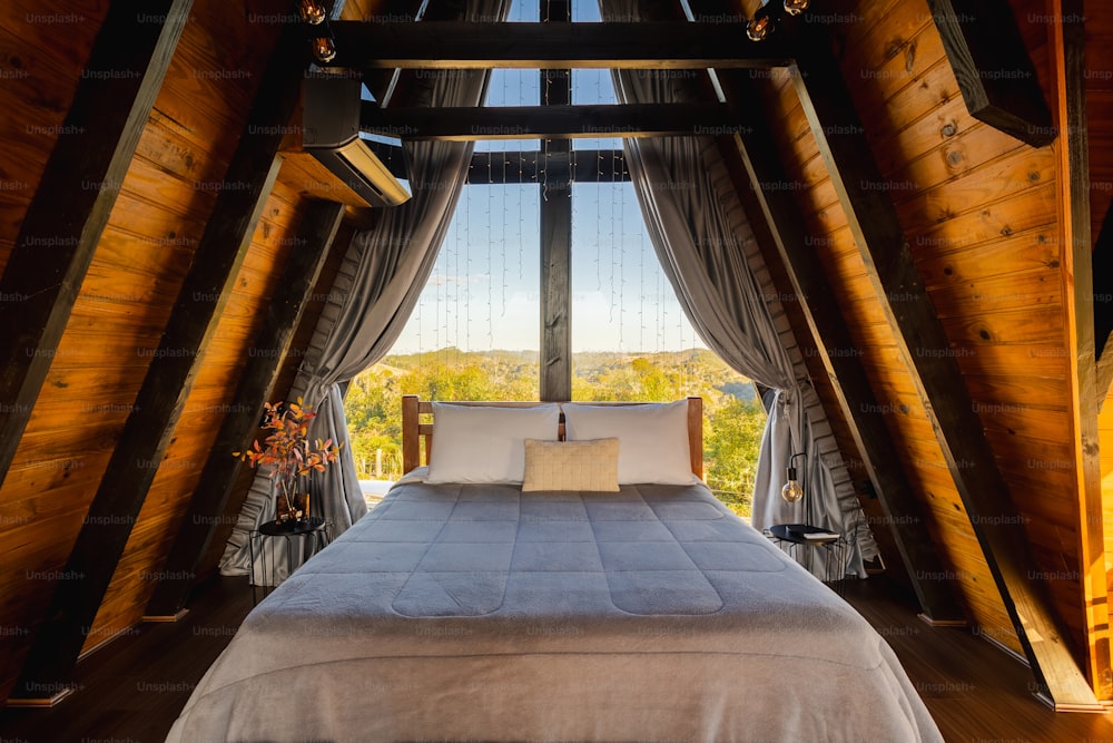 uma cama em um quarto com vista para as árvores