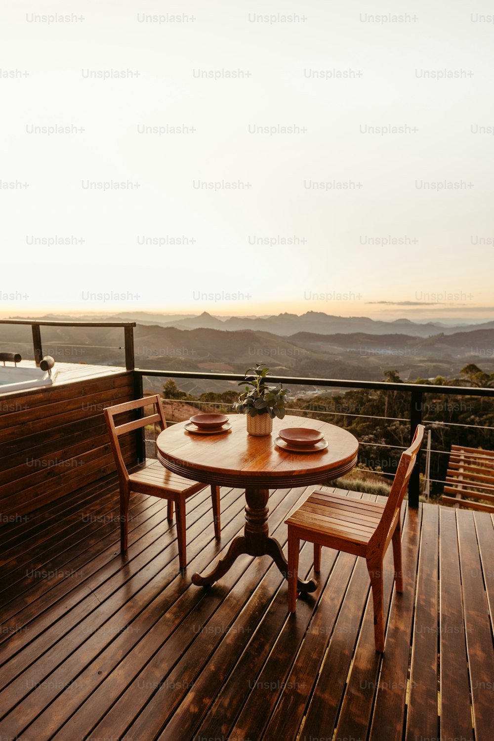 une table et deux chaises sur une terrasse en bois