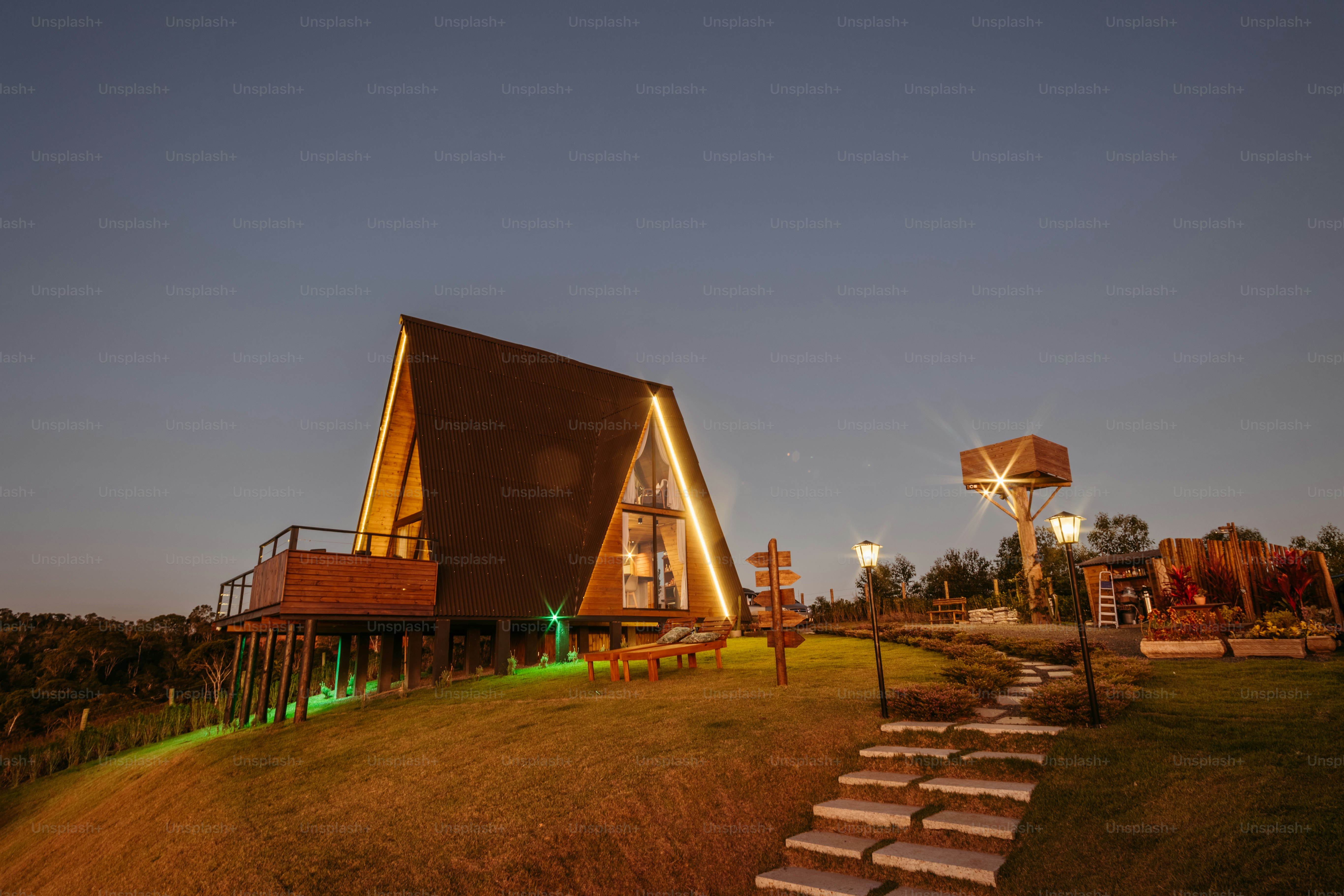 a couple of houses sitting on top of a lush green hillside