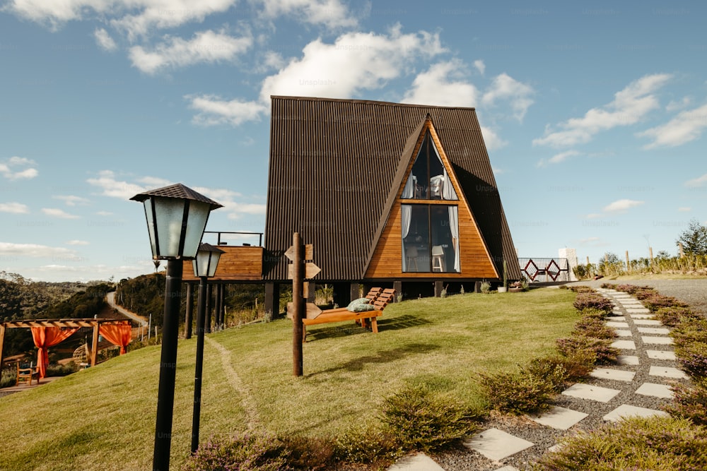 uma casa de madeira com um telhado marrom em uma colina