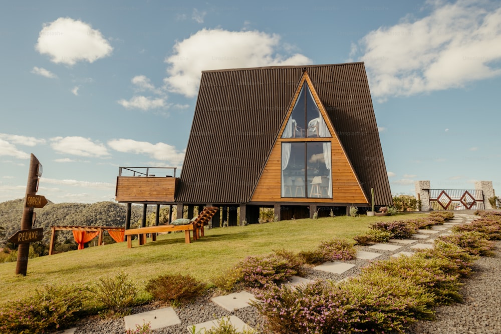 a wooden building with a large glass window on top of a hill