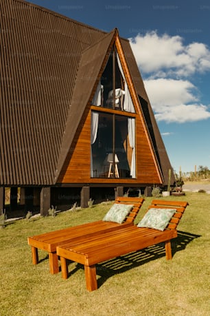 a wooden chaise lounge in front of a house
