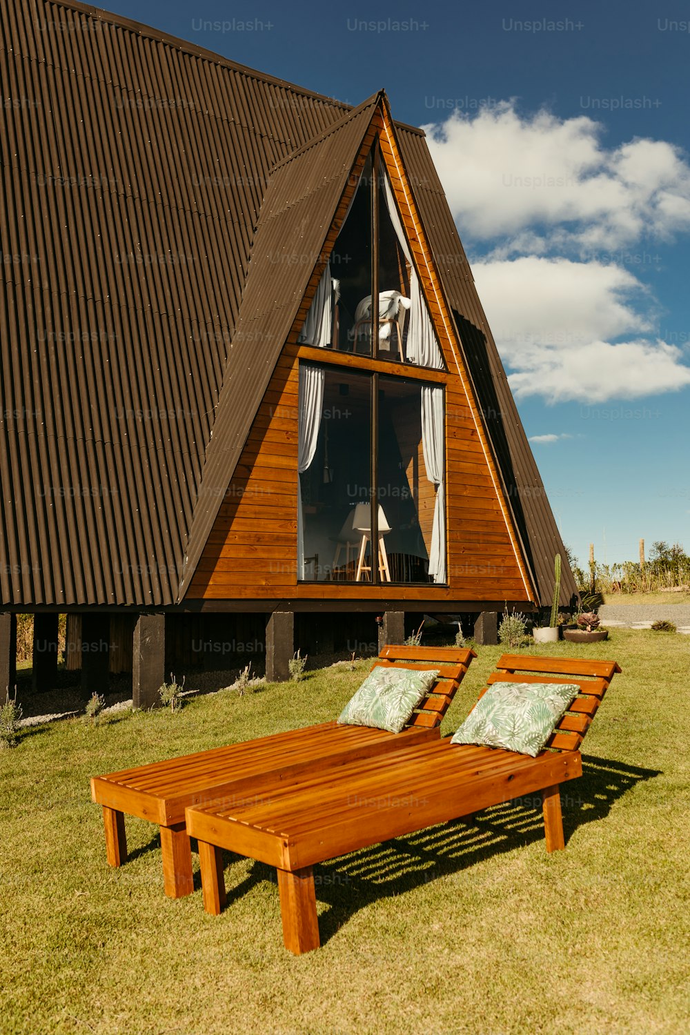 a wooden chaise lounge in front of a house