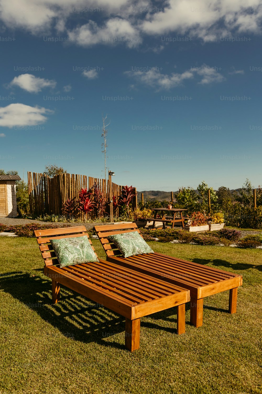 a wooden bench sitting on top of a lush green field