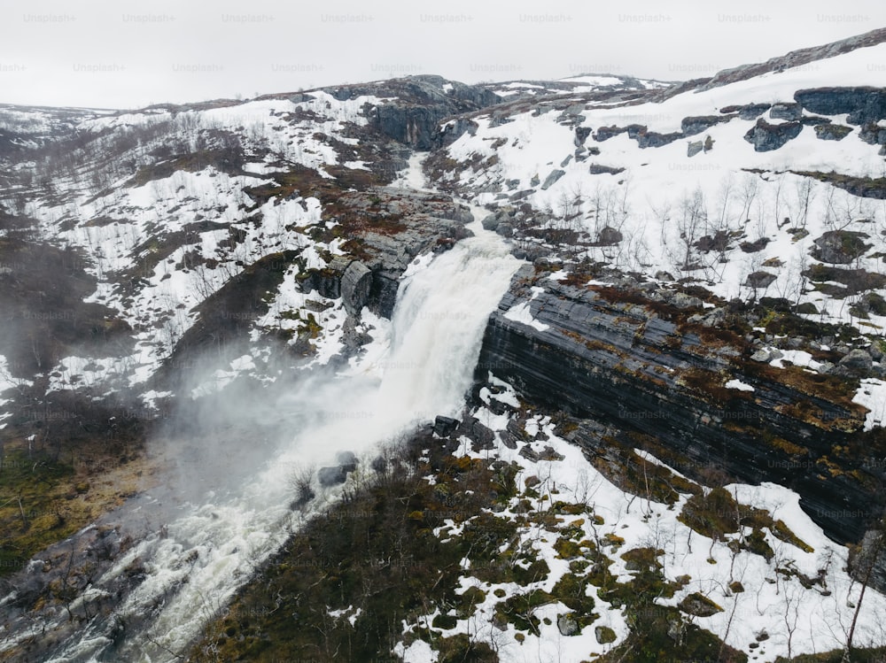 an aerial view of a waterfall in the mountains