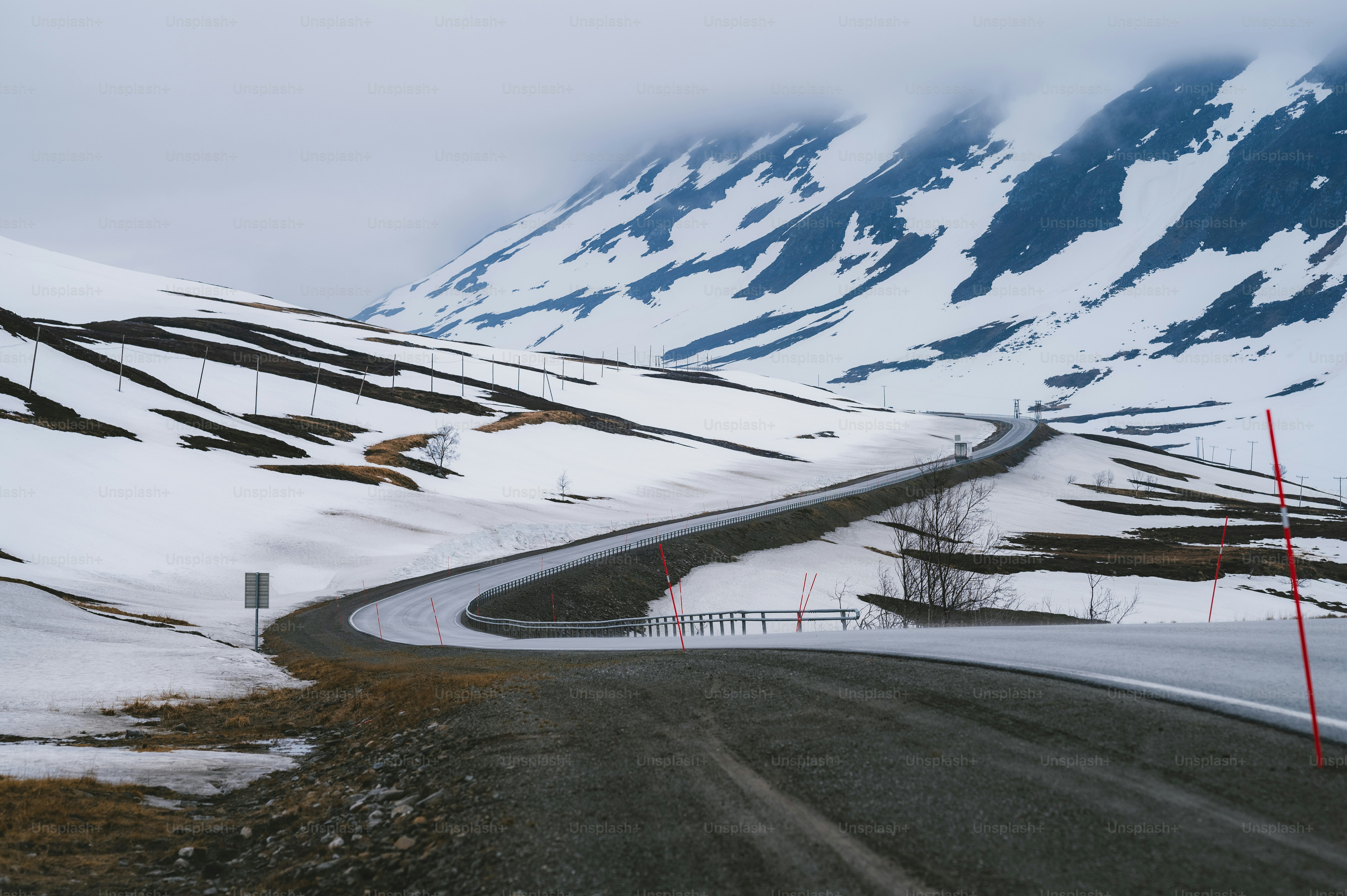 a long winding road in the mountains covered in snow