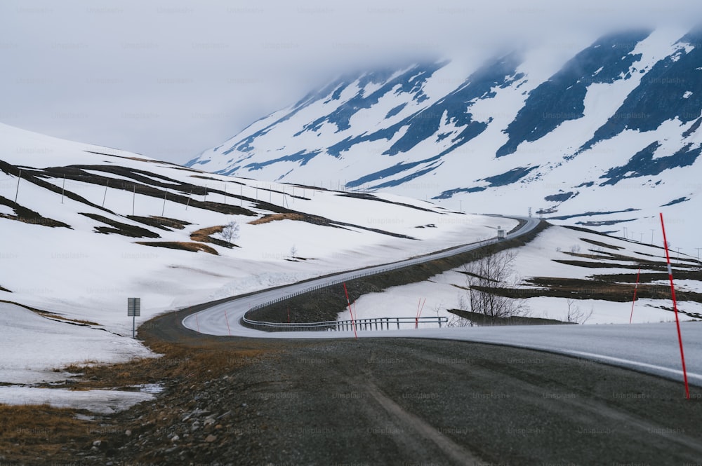Eine lange, kurvenreiche Straße in den schneebedeckten Bergen