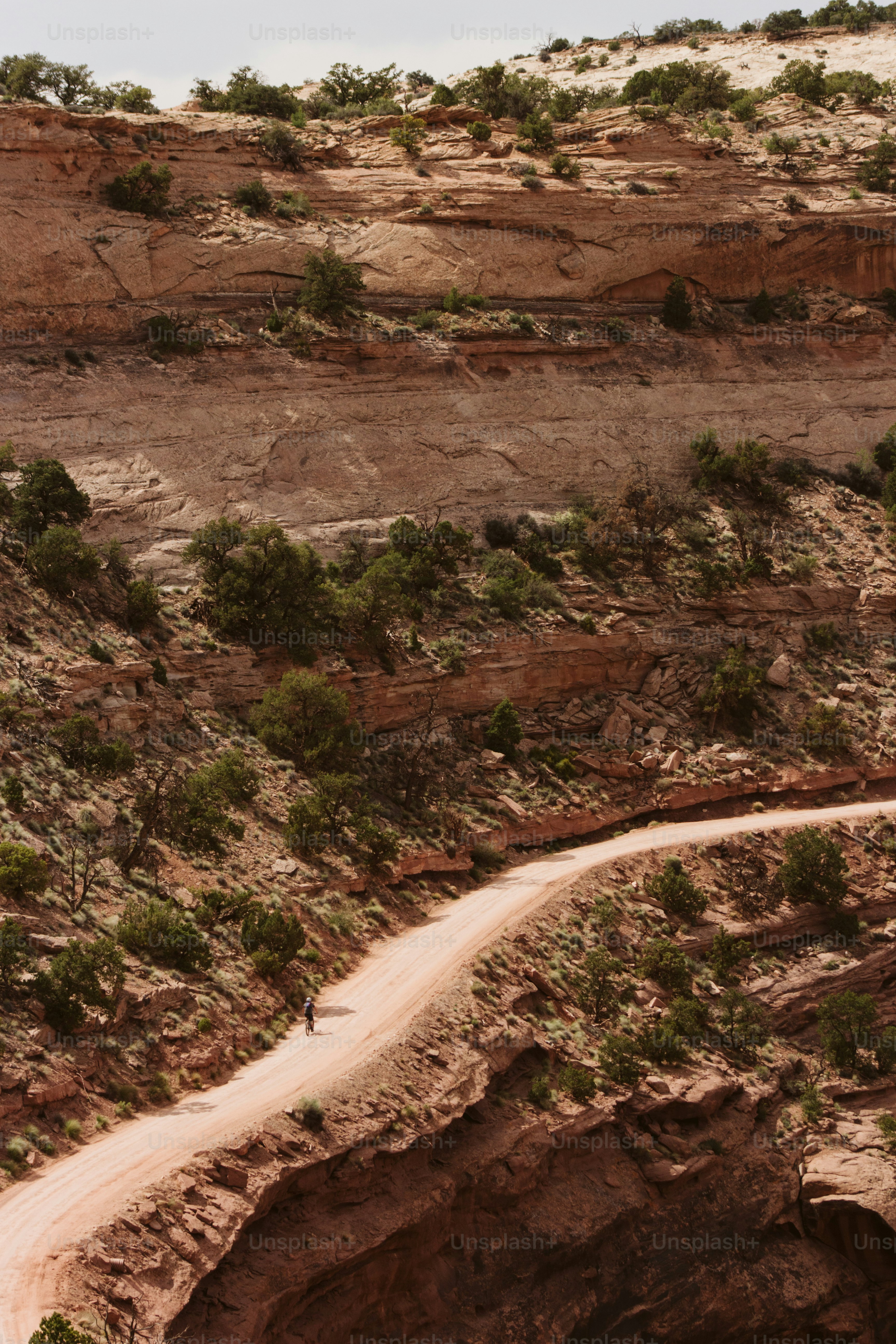 a man riding a motorcycle down a dirt road