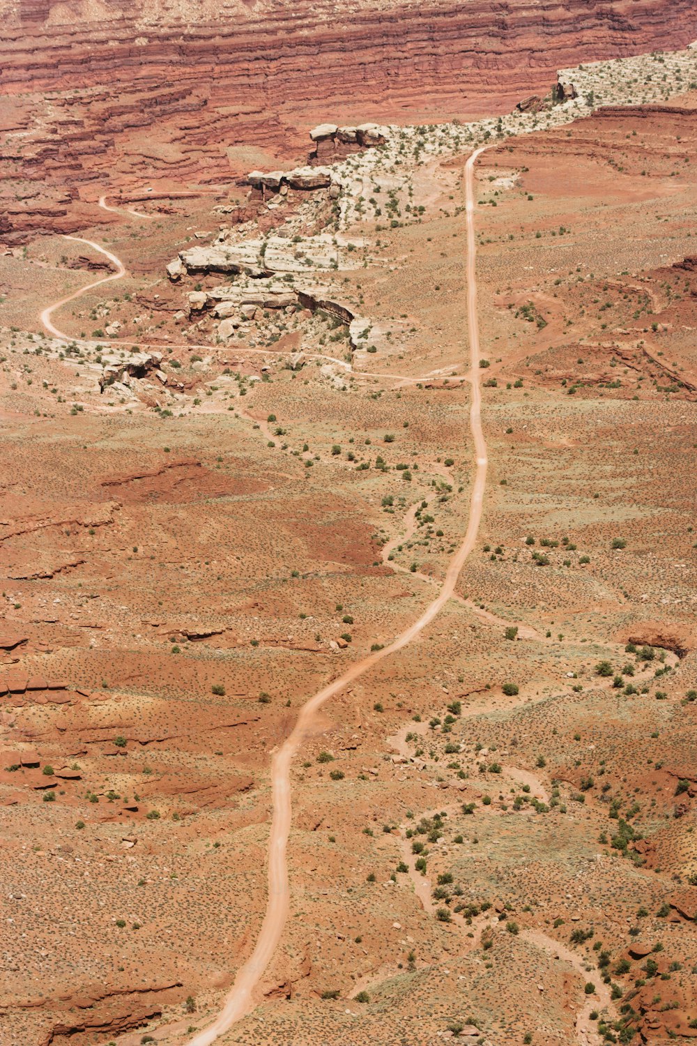 an aerial view of a dirt road in the desert