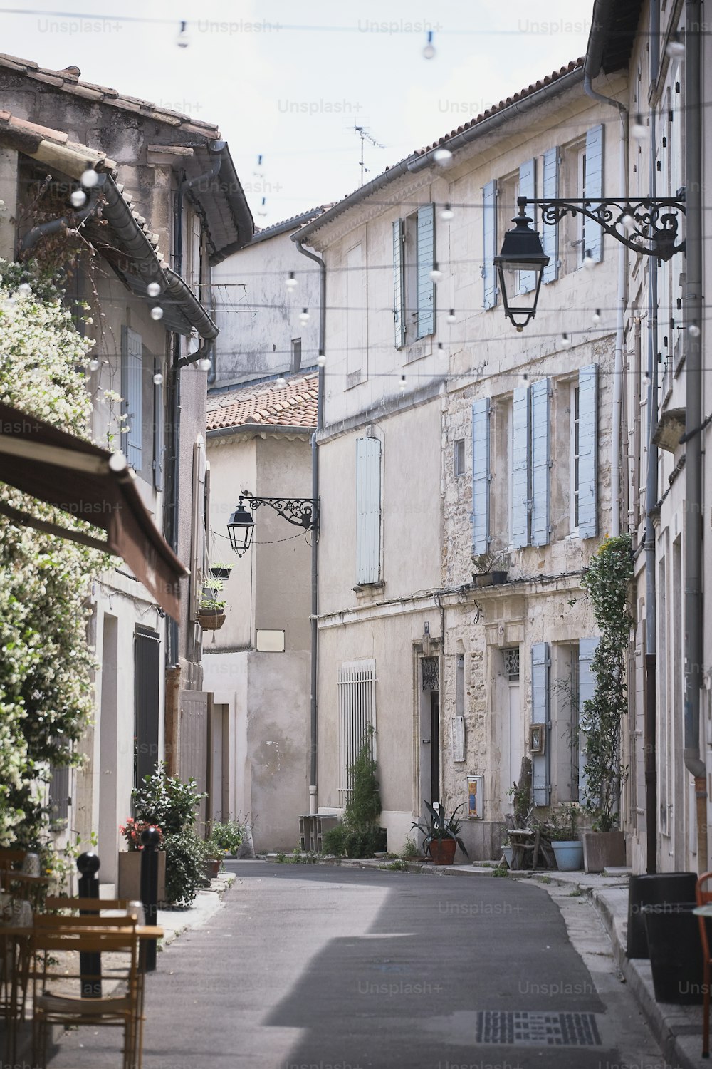 a narrow street with tables and chairs on both sides