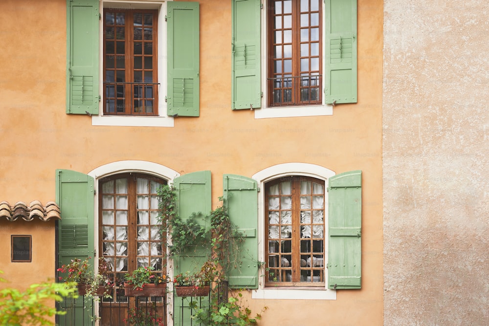 a tall building with green shutters and windows