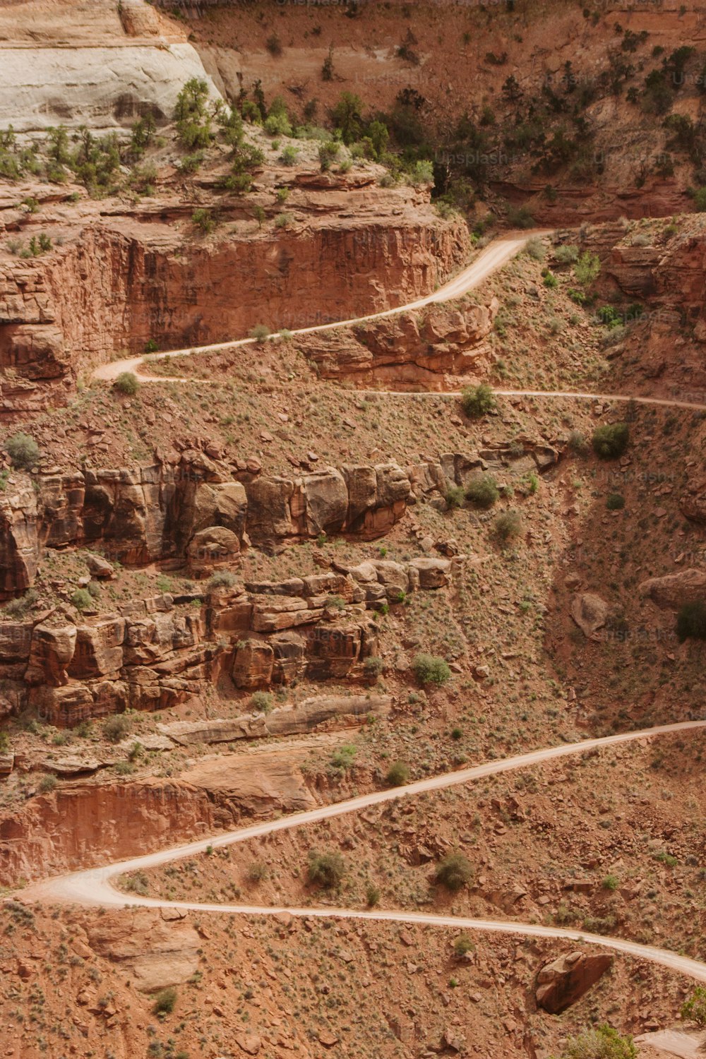 a winding dirt road in the middle of a canyon