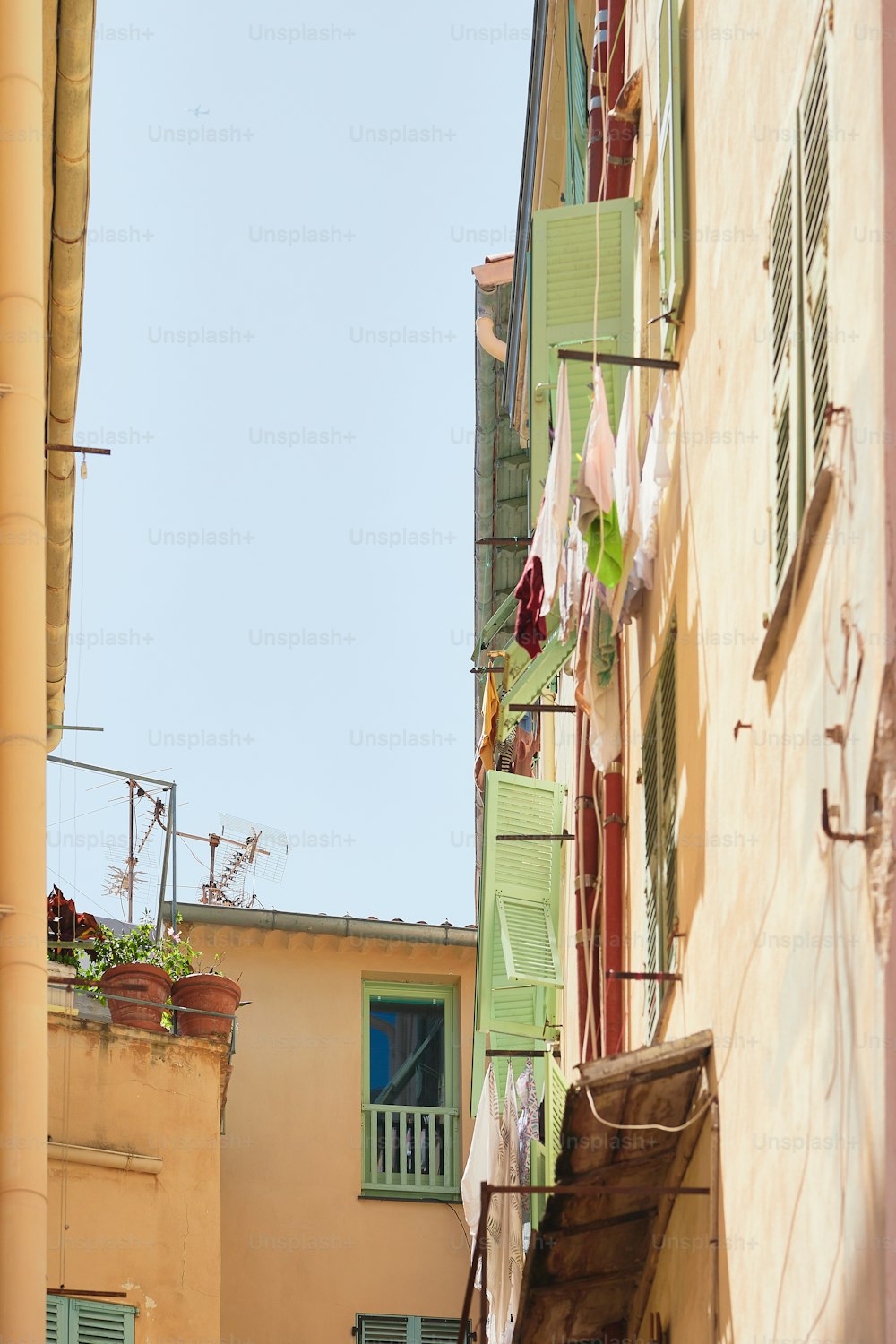 a narrow alleyway with clothes hanging on a line