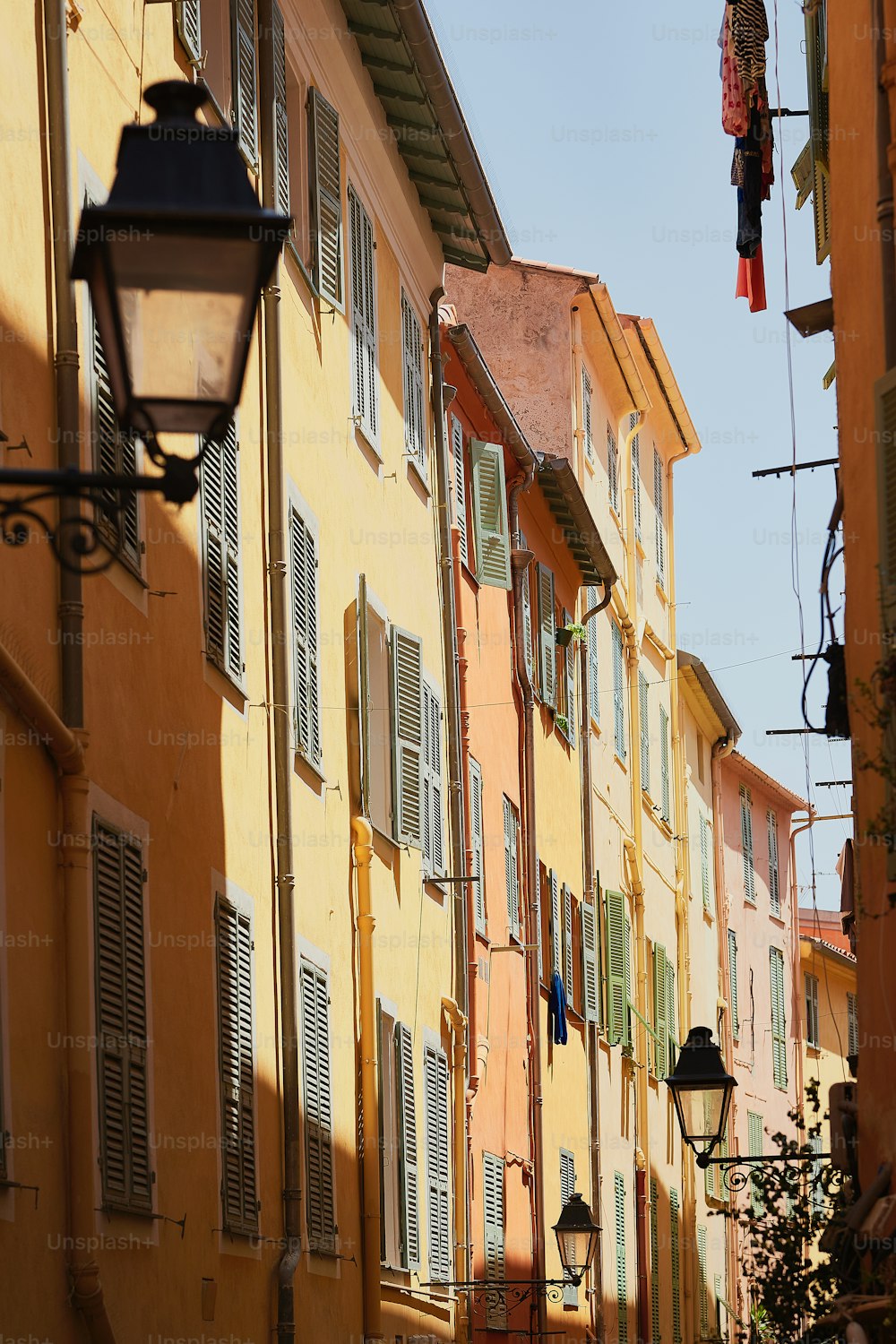 a row of yellow buildings with green shutters