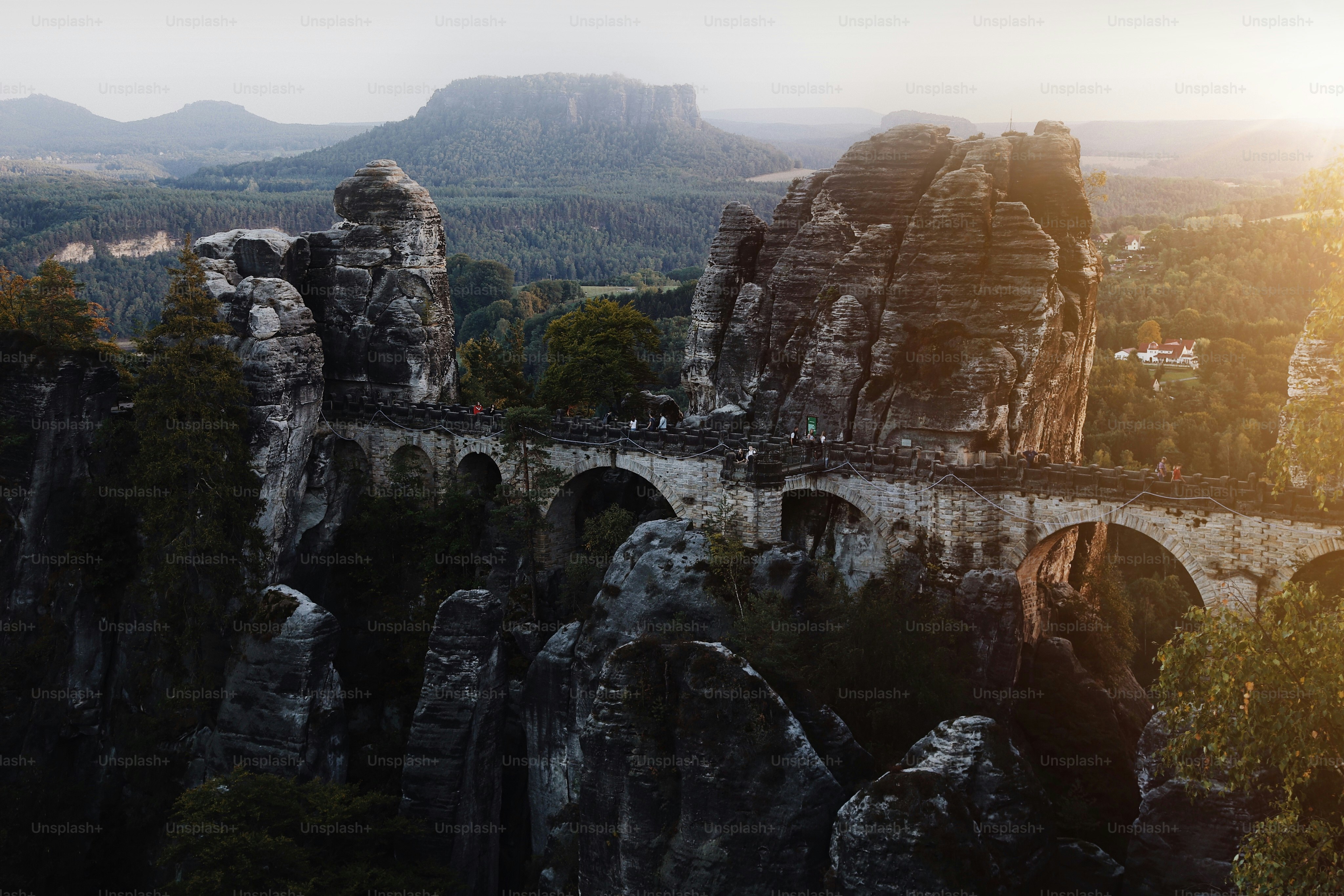 a stone bridge over a river surrounded by mountains