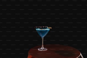 Un cocktail blu seduto sopra un tavolo di legno