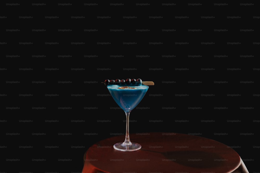 Un cocktail blu seduto sopra un tavolo di legno