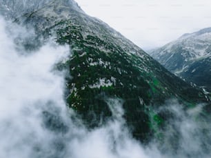 an aerial view of a mountain range in the clouds