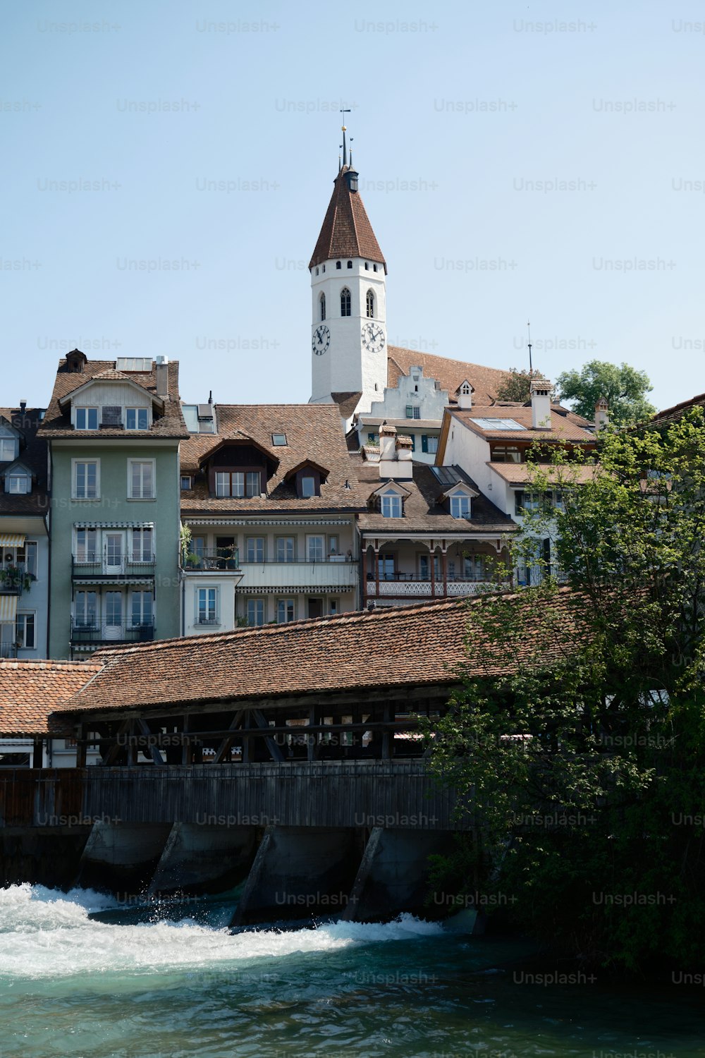 un edificio con una torre dell'orologio vicino a un fiume