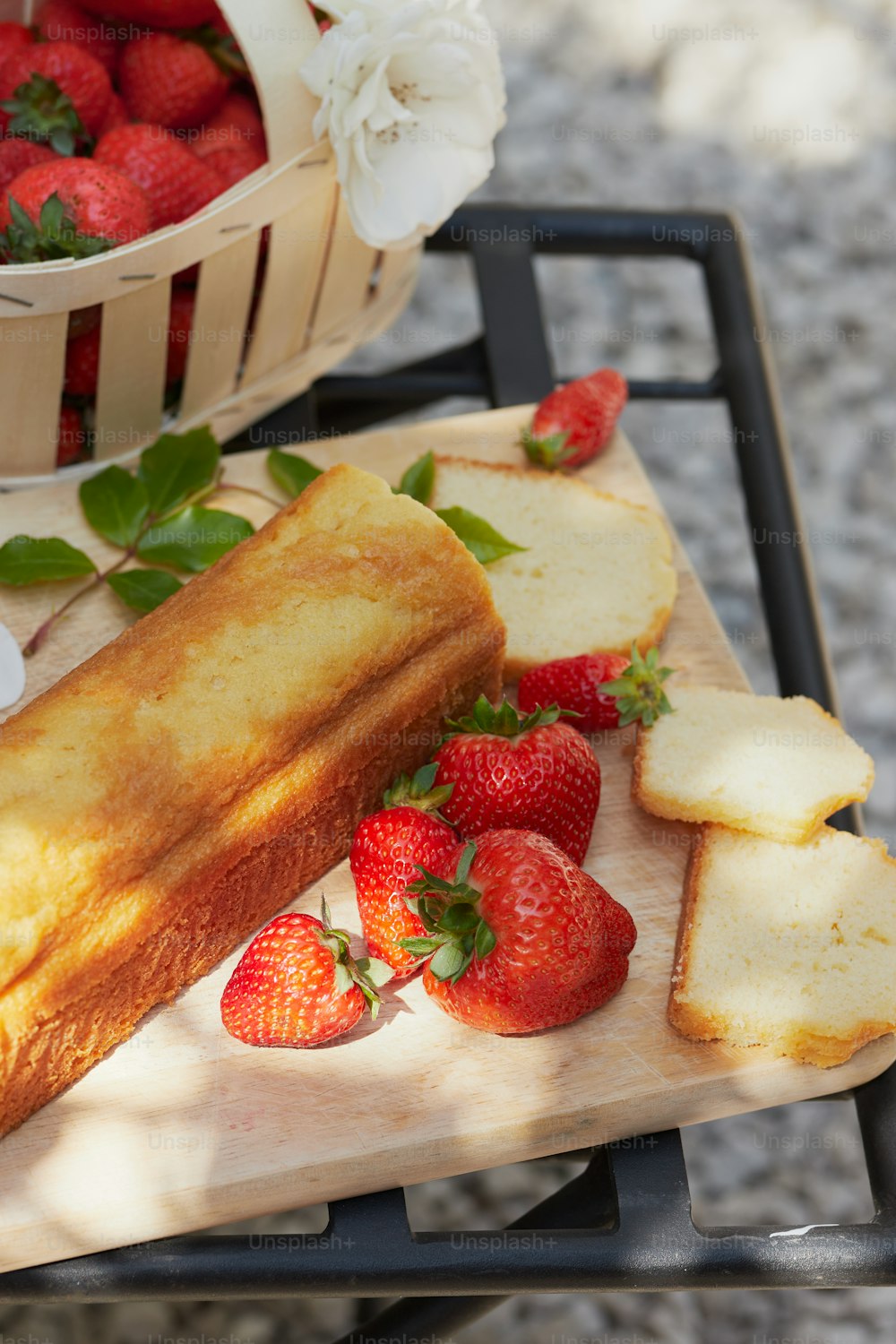 a wooden cutting board topped with sliced bread and strawberries
