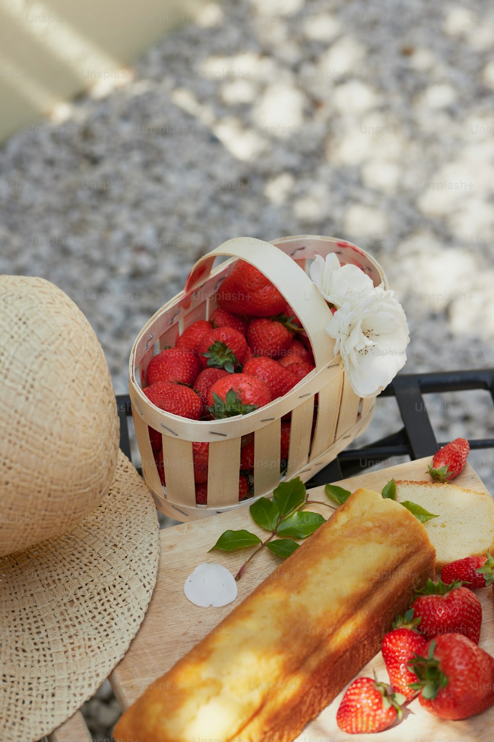 a basket of strawberries sitting next to a piece of bread
