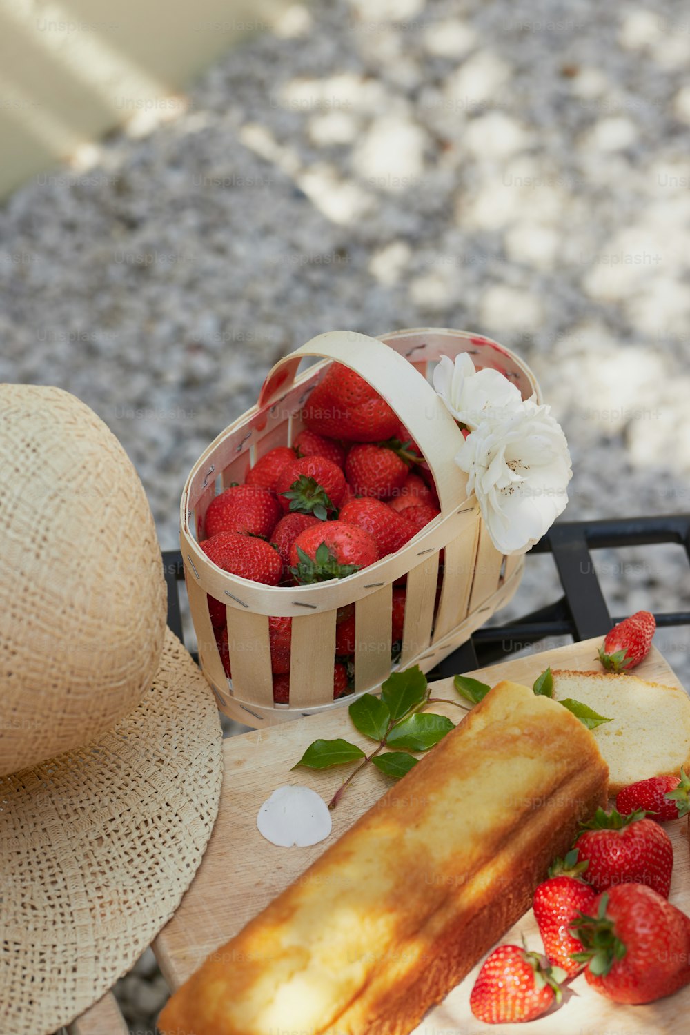 un panier de fraises assis à côté d’un morceau de pain