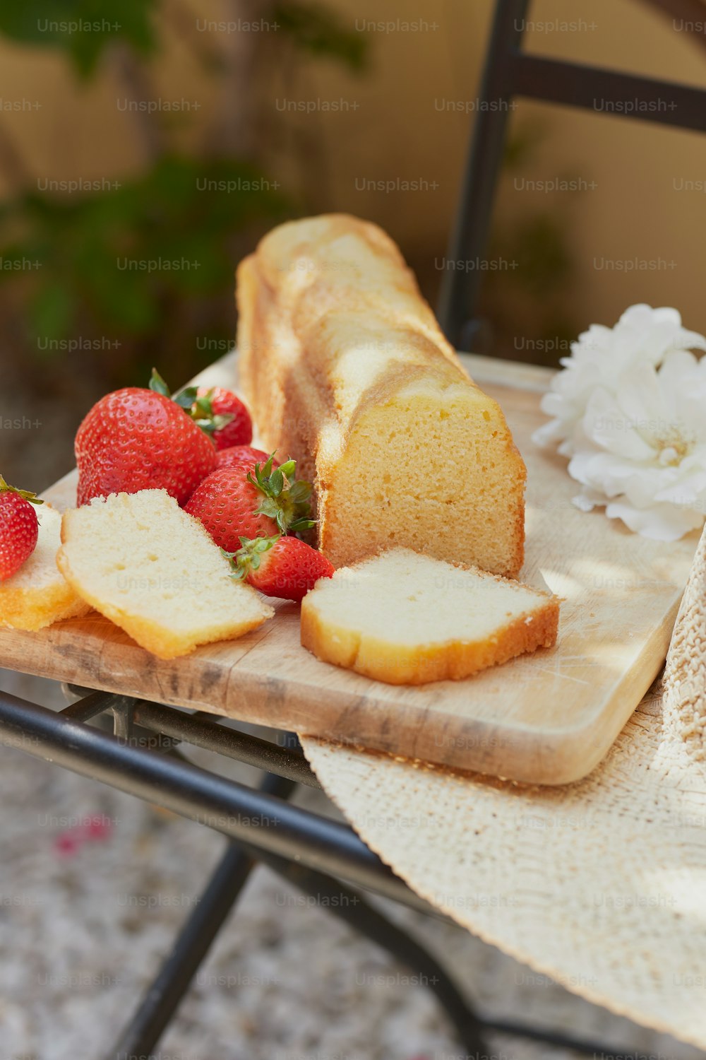 ein Tisch mit einem Laib Brot und geschnittenen Erdbeeren