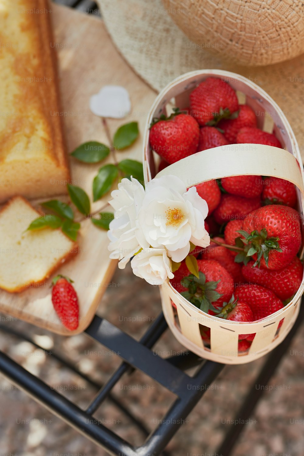 a basket of strawberries next to a piece of bread