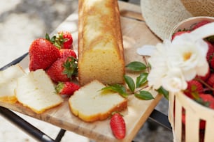 ein Tisch mit einem Laib Brot und geschnittenen Erdbeeren