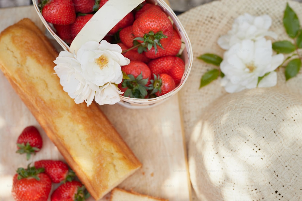 a basket of strawberries next to a piece of bread
