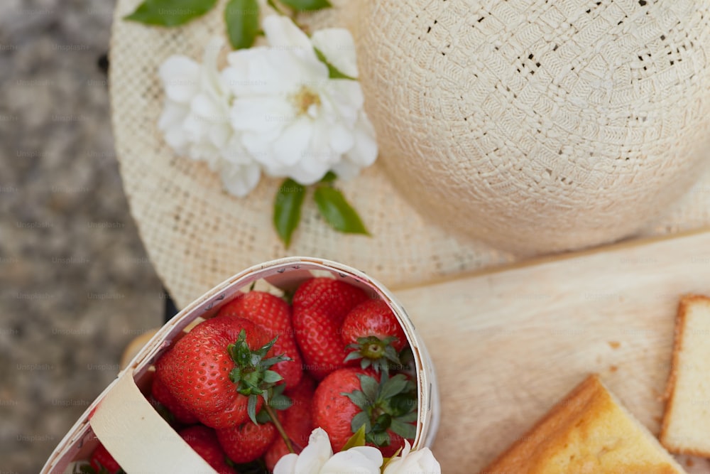 a basket of strawberries next to a piece of bread