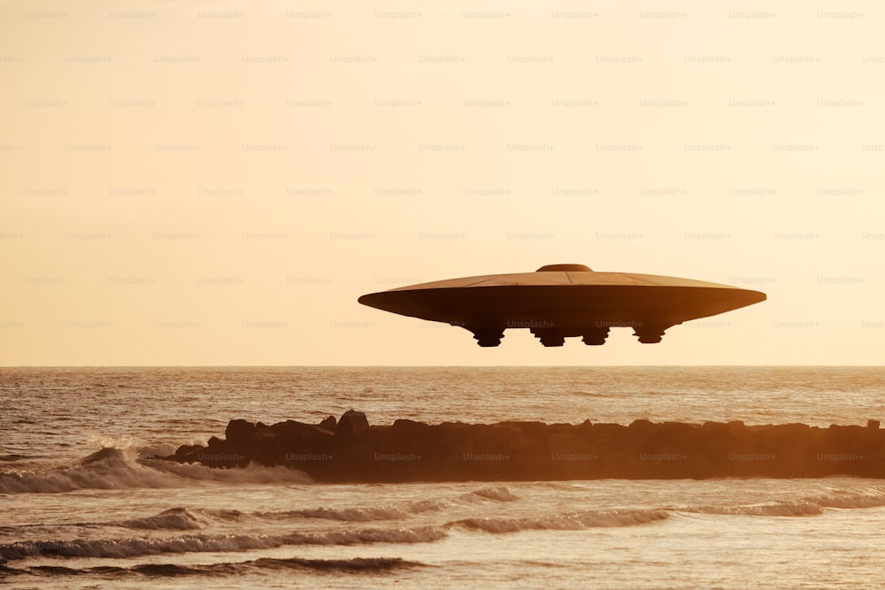 a large object flying over a body of water