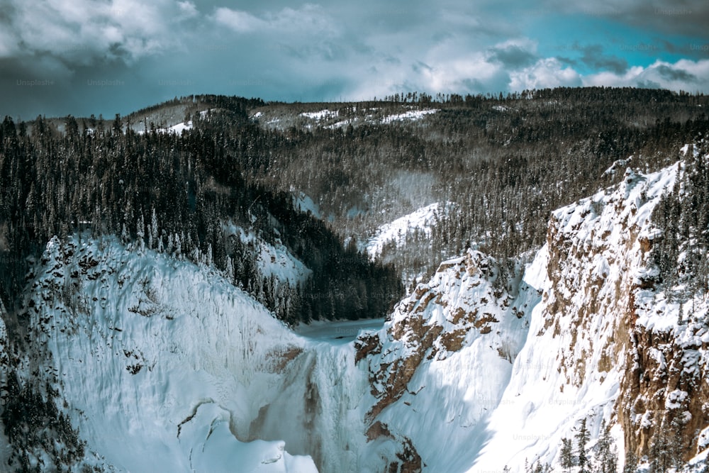 a large waterfall surrounded by snow covered mountains