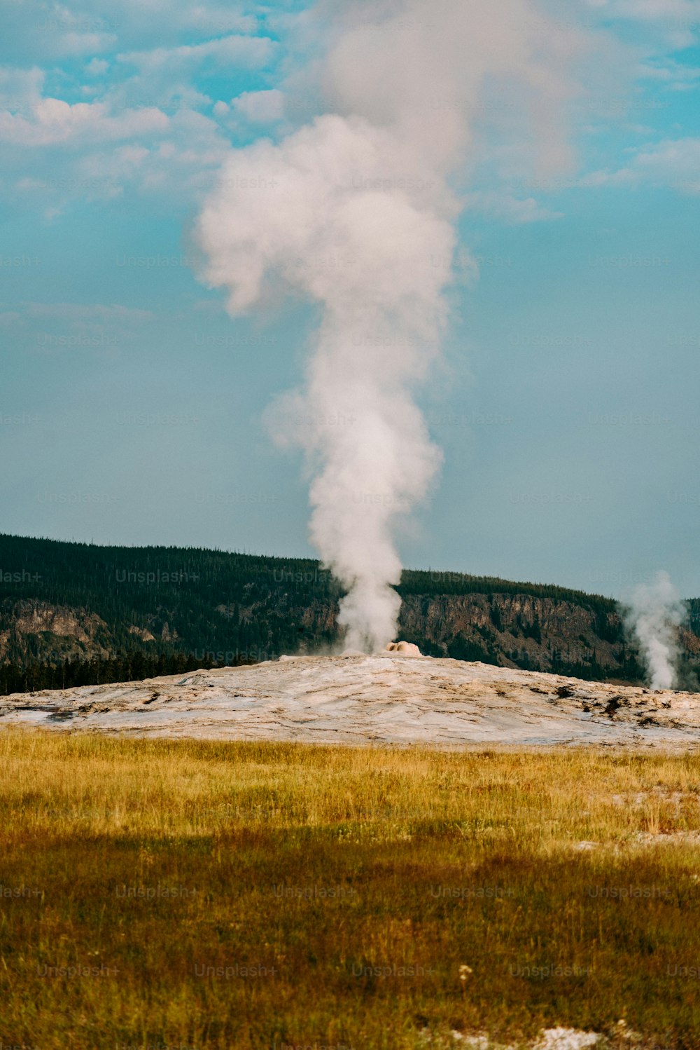 Ein Geysir stößt Dampf aus, wenn er in den Himmel steigt