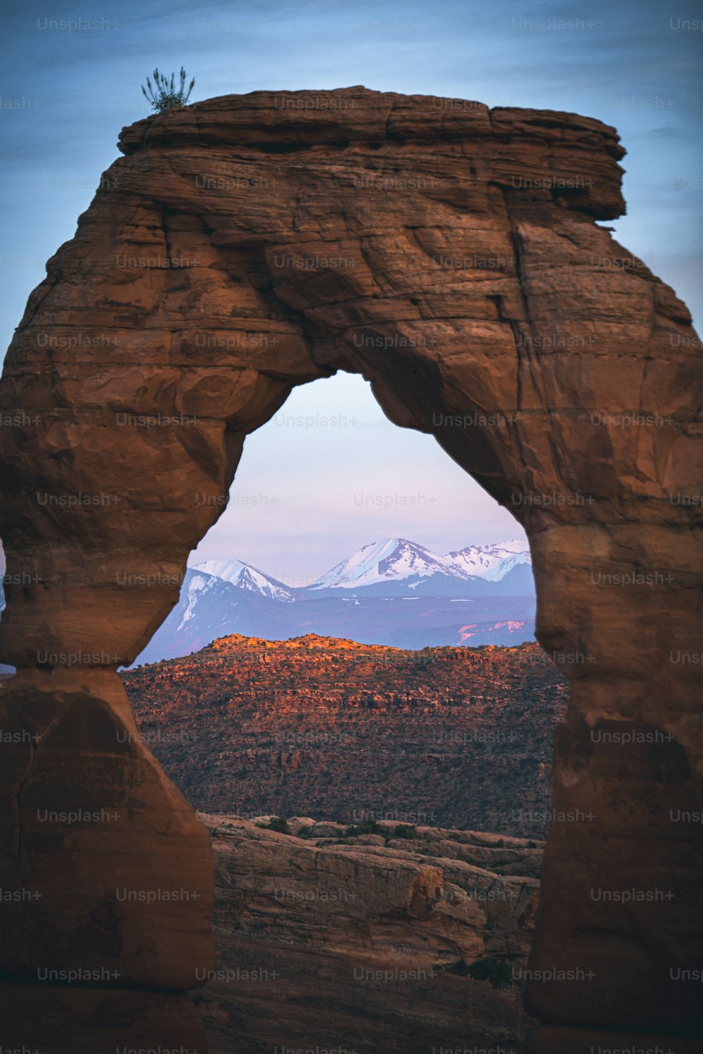Un gran arco de roca con una montaña al fondo