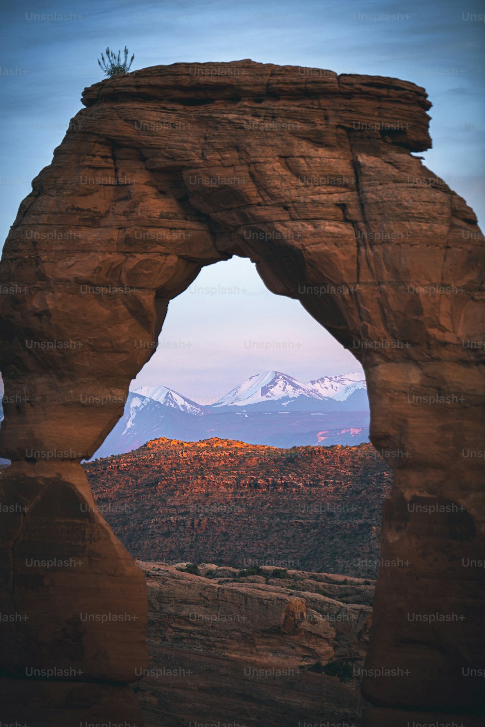 a large rock arch with a mountain in the background