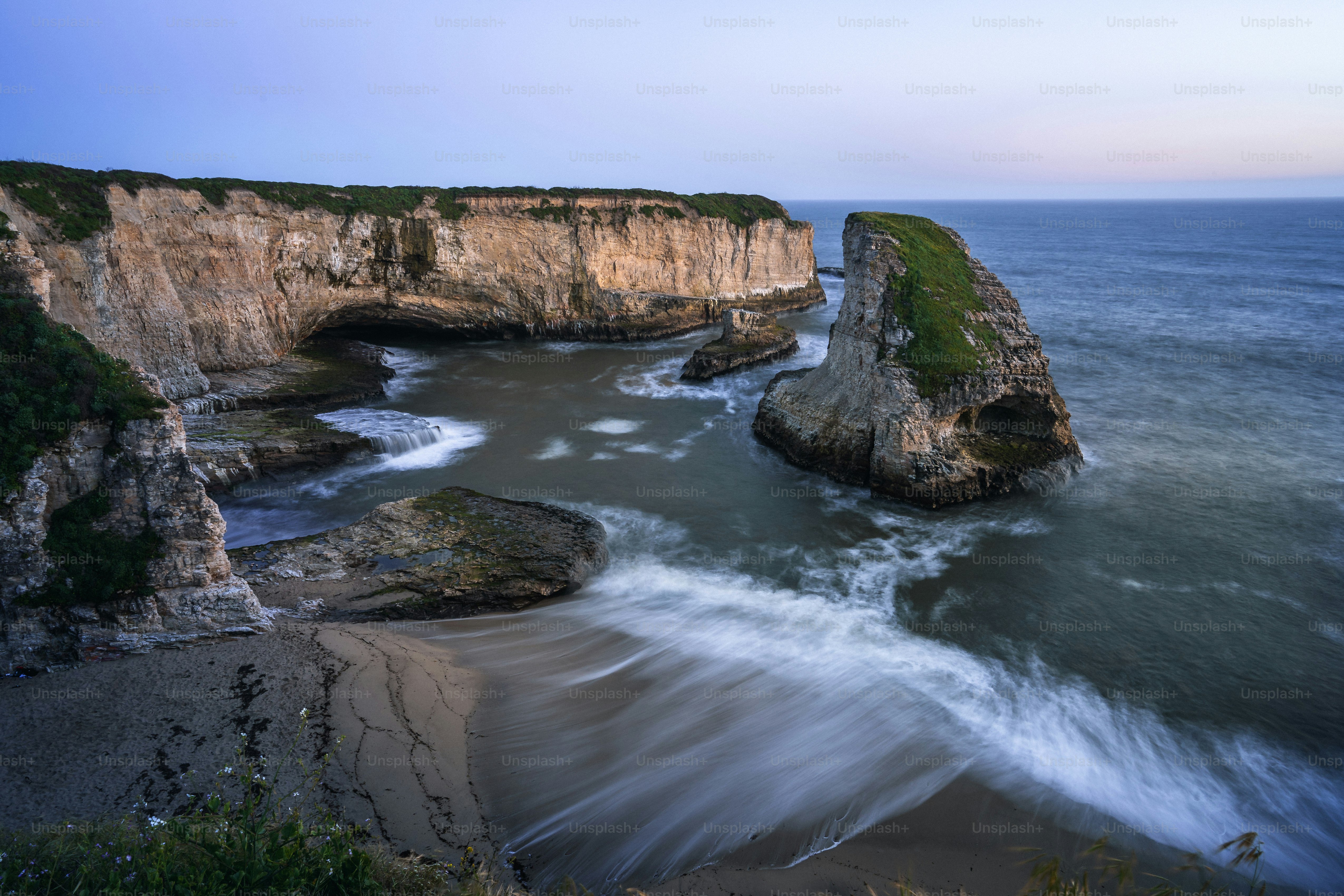 a large body of water next to a rocky cliff
