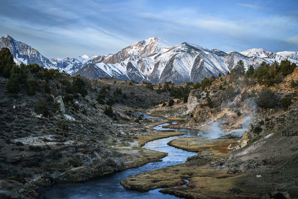 a river running through a valley surrounded by mountains