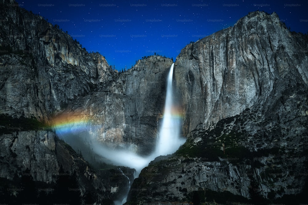 uma cachoeira com um arco-íris no meio dela